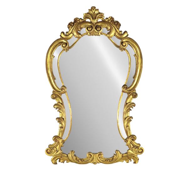 French mirror of the Louis XV line with arched shape, in gilded wood and carved with motifs of volutes and curls