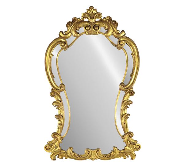 Specchiera francese di linea Luigi XV a forma centinata, in legno dorato e intagliato a motivi di volute e ricci