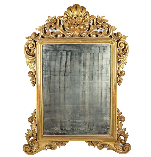 Specchiera napoletana Luigi Filippo in legno dorato e intagliato a motivi di volute di foglie d'acanto, ricci, fiori e foglie, al centro della cimasa conchiglia. Specchio al mercurio