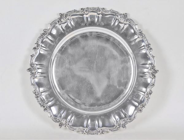 Piatto tondo in argento con bordo cesellato e sbalzato a volute di foglie d'acanto, gr. 760