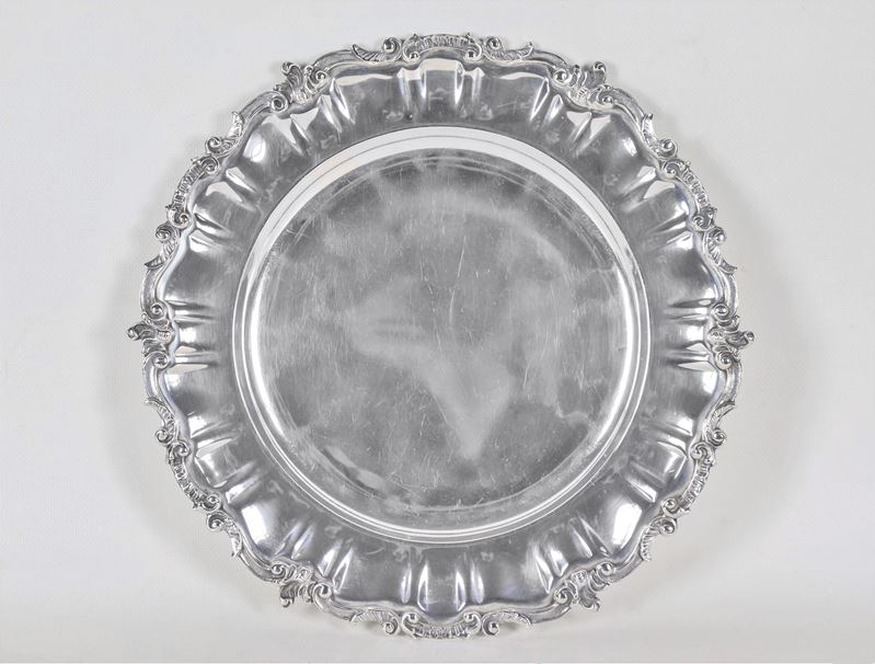 Piatto tondo in argento con bordo cesellato e sbalzato a volute di foglie d'acanto, gr. 760