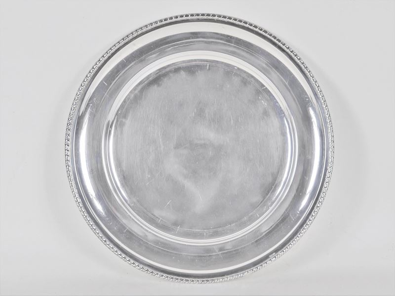 Piatto tondo da portata in argento con bordo a baccellature, gr. 530