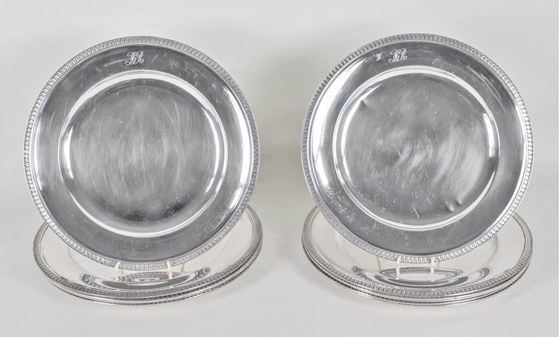 Lotto di dodici sottopiatti in argento con bordi cesellati a palmette neoclassiche e monogramma i...