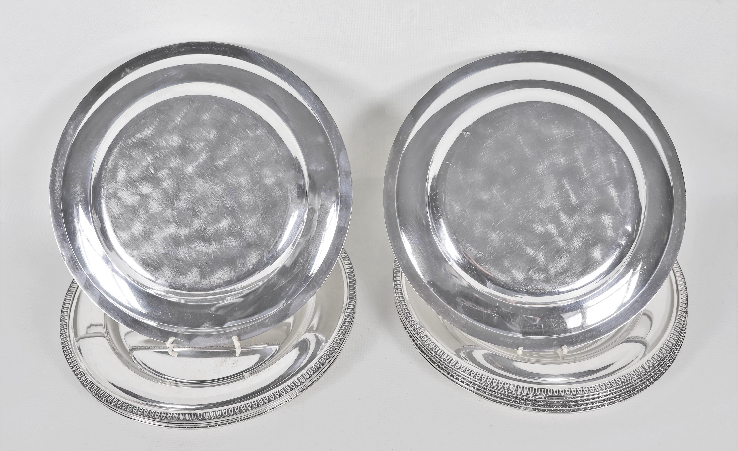Lotto di dodici sottopiatti in argento con bordi cesellati a palmette neoclassiche e monogramma i...