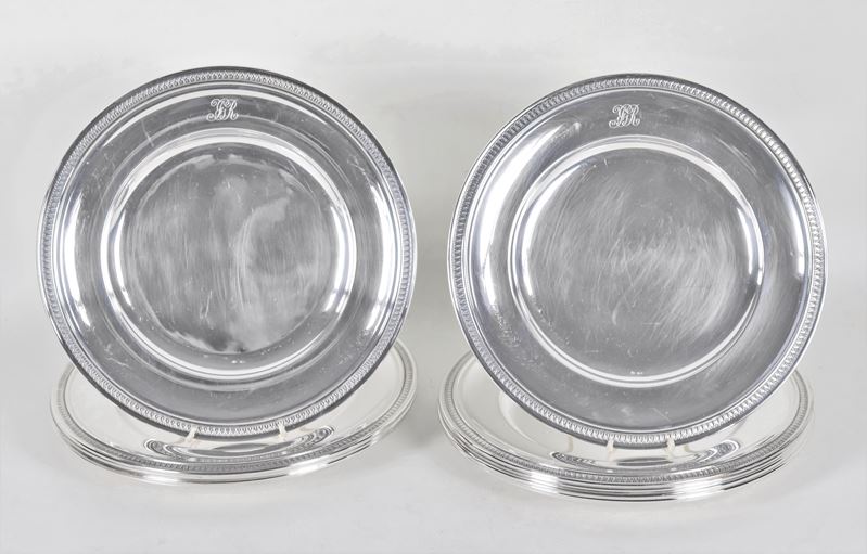 Lotto di dodici piatti tondi in argento con bordi cesellati a palmette neoclassiche e monogramma ...