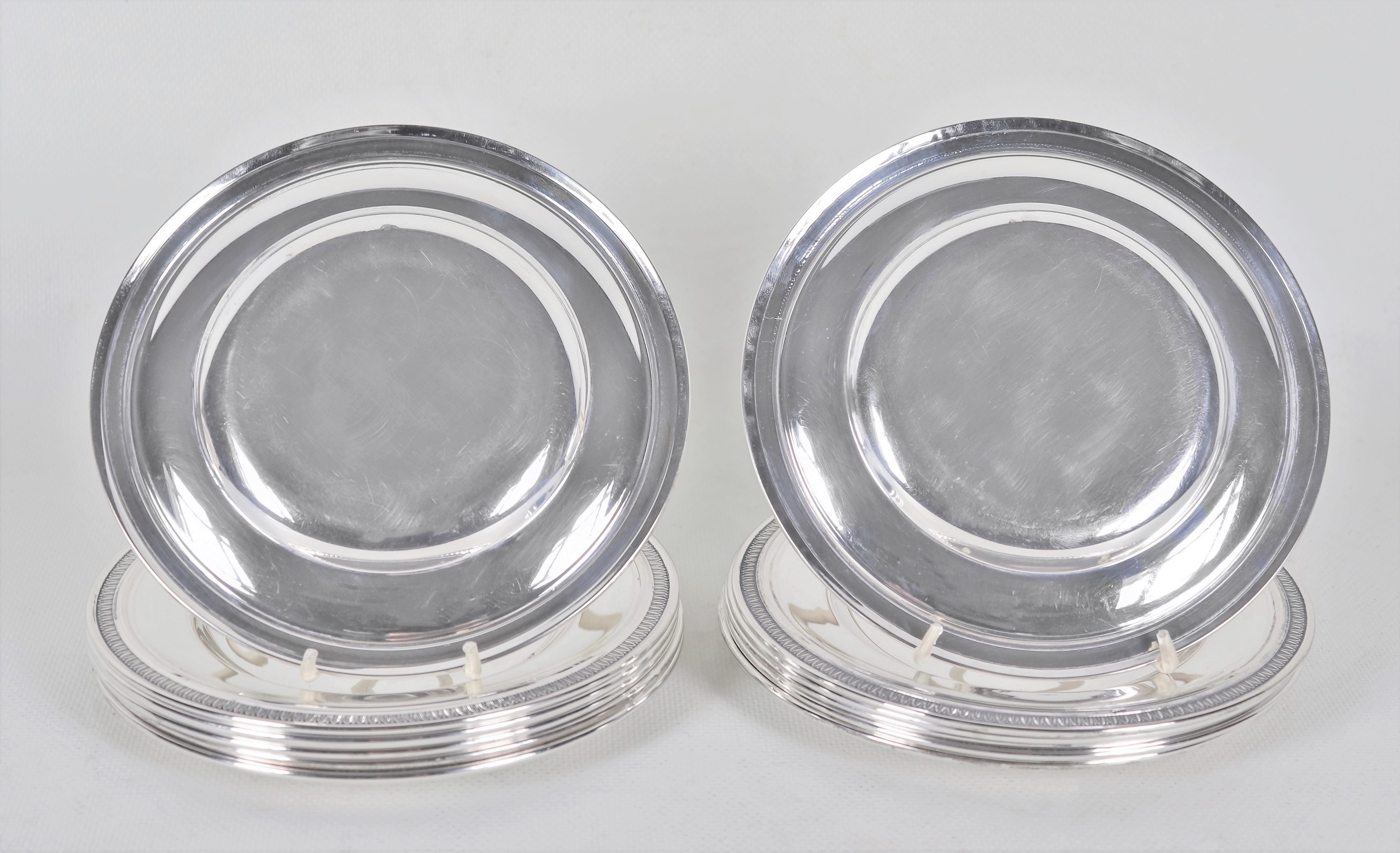 Lotto di dodici piattini per il pane in argento, con bordi cesellati a palmette neoclassiche e mo...