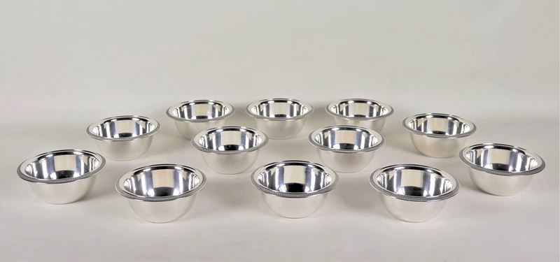 Lotto di dodici coppette lavamani in argento, con bordi cesellati a palmette neoclassiche, gr. 11...