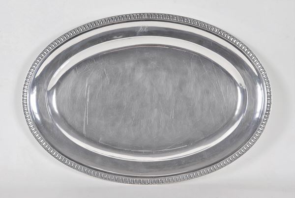 Large oval silver serving plate, with chiselled edge with neoclassical palmettes and engraved monogram, gr. 1350