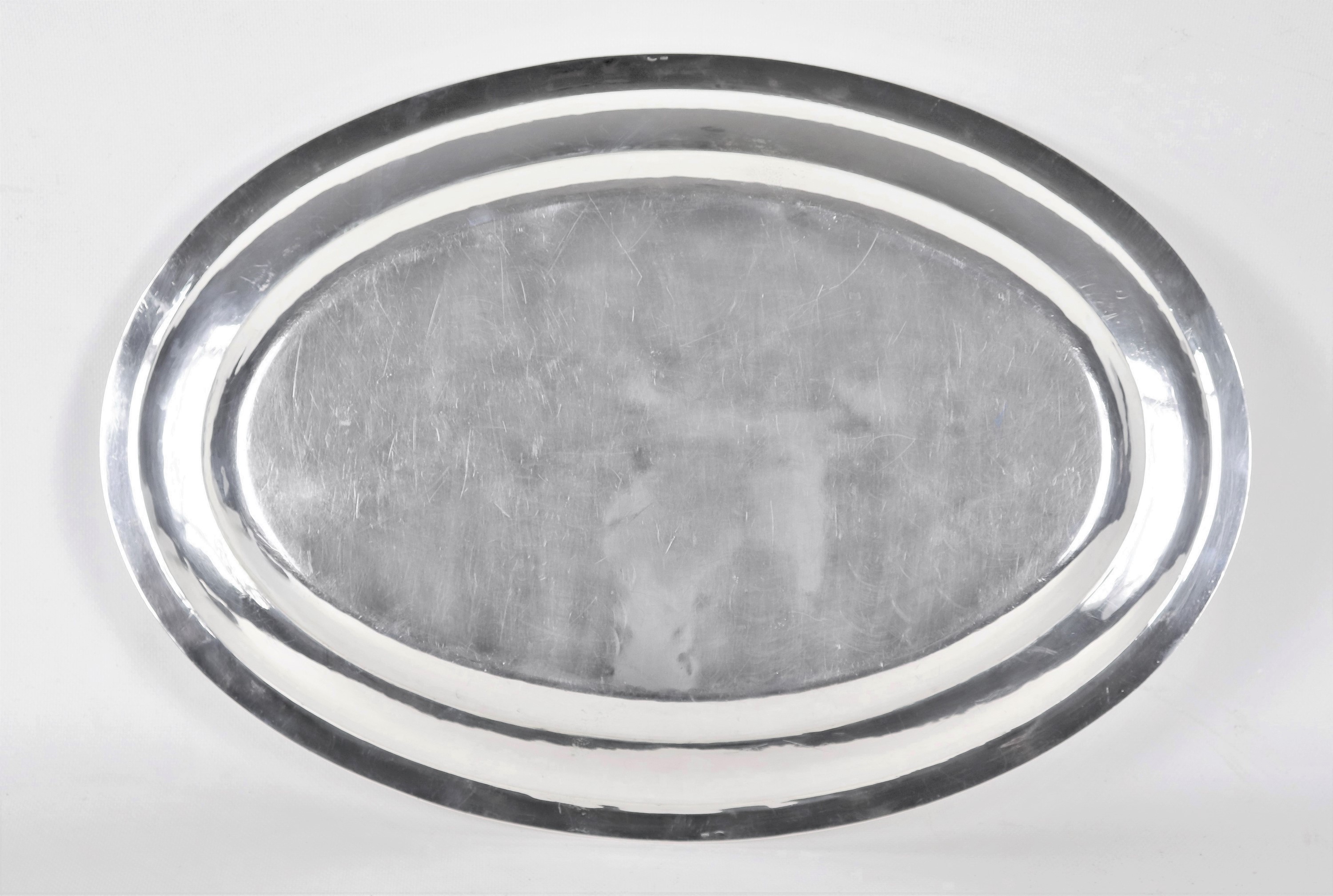 Grande piatto ovale da portata in argento, con bordo cesellato a palmette neoclassiche e monogram...