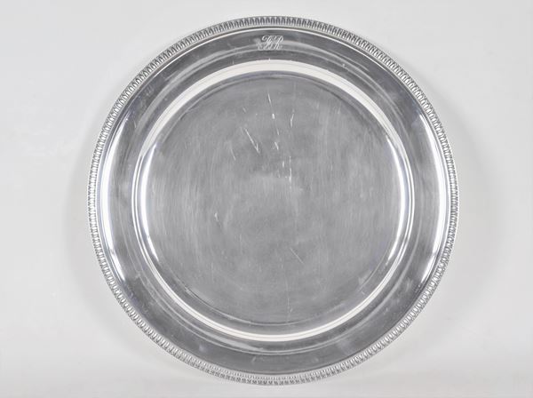 Grande piatto tondo da portata in argento, con bordo cesellato a palmette neoclassiche e monogramma inciso, gr. 1210