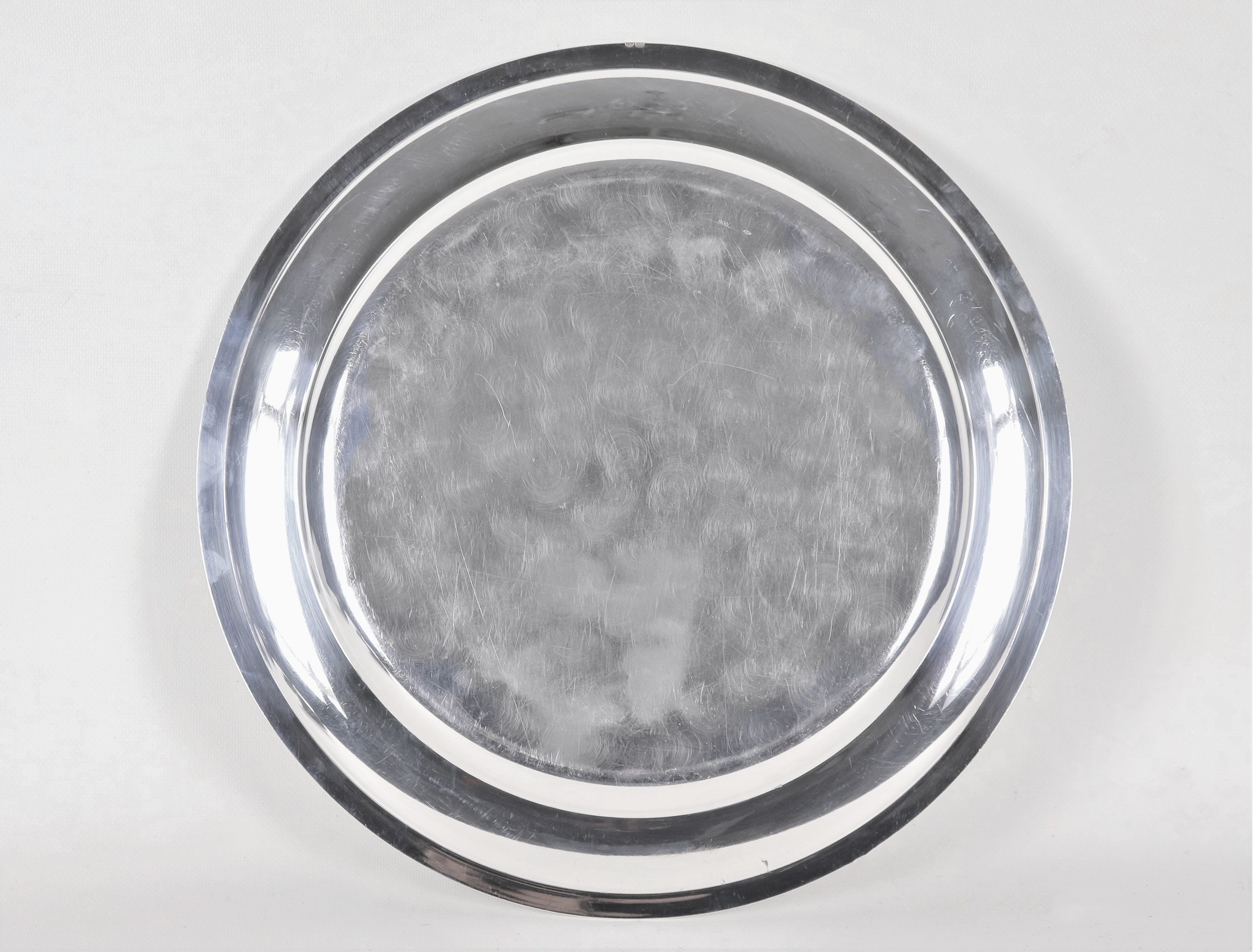 Grande piatto tondo da portata in argento, con bordo cesellato a palmette neoclassiche e monogram...