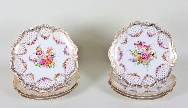 Lot of eight dessert plates in white Dresden porcelain, entirely decorated and colorful with floral garlands and bunches of flowers, highlights in pure gold