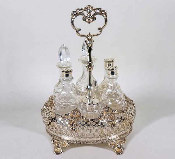 Cruet inglese Giorgio IV in Sheffield cesellato, sbalzato e traforato a motivi di volute e conchiglie, sorretta da quattro piedini ricurvi, sei flaconi in cristallo