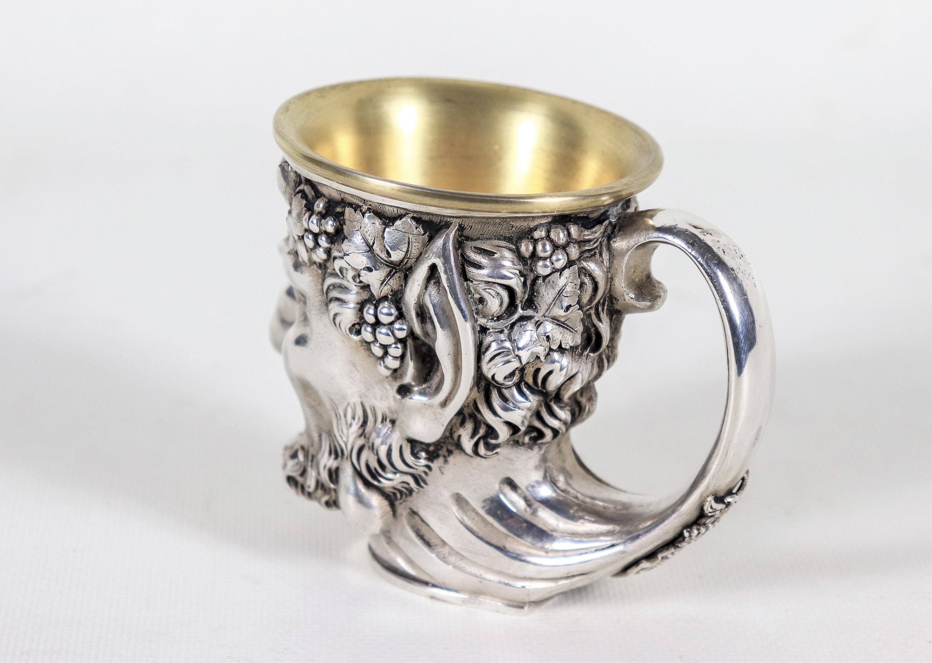 Piccolo boccale in argento, scolpito con testa di Bacco e grappoli d'uva, all'interno incisione c...