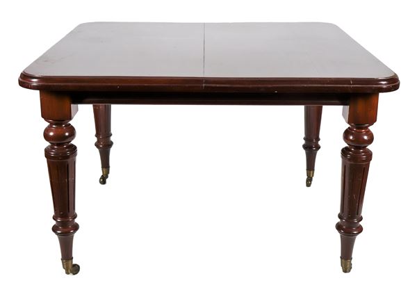 Tavolo da pranzo inglese Vittoriano allungabile in mogano massello, a forma rettangolare con quattro gambe tornite e baccellate, apertura con meccanismo a manovella e una tavola di prolunga