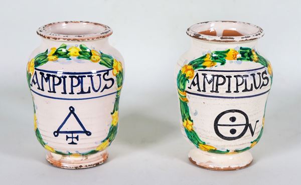 Pair of small pharmacy albarelli in glazed Italian majolica, with colorful decorations with laurel wreath motifs and an inscription in the center
