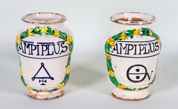 Coppia di piccoli albarelli da farmacia in maiolica italiana smaltata, con decorazioni variopinte a motivi di corone d'alloro e iscrizione al centro