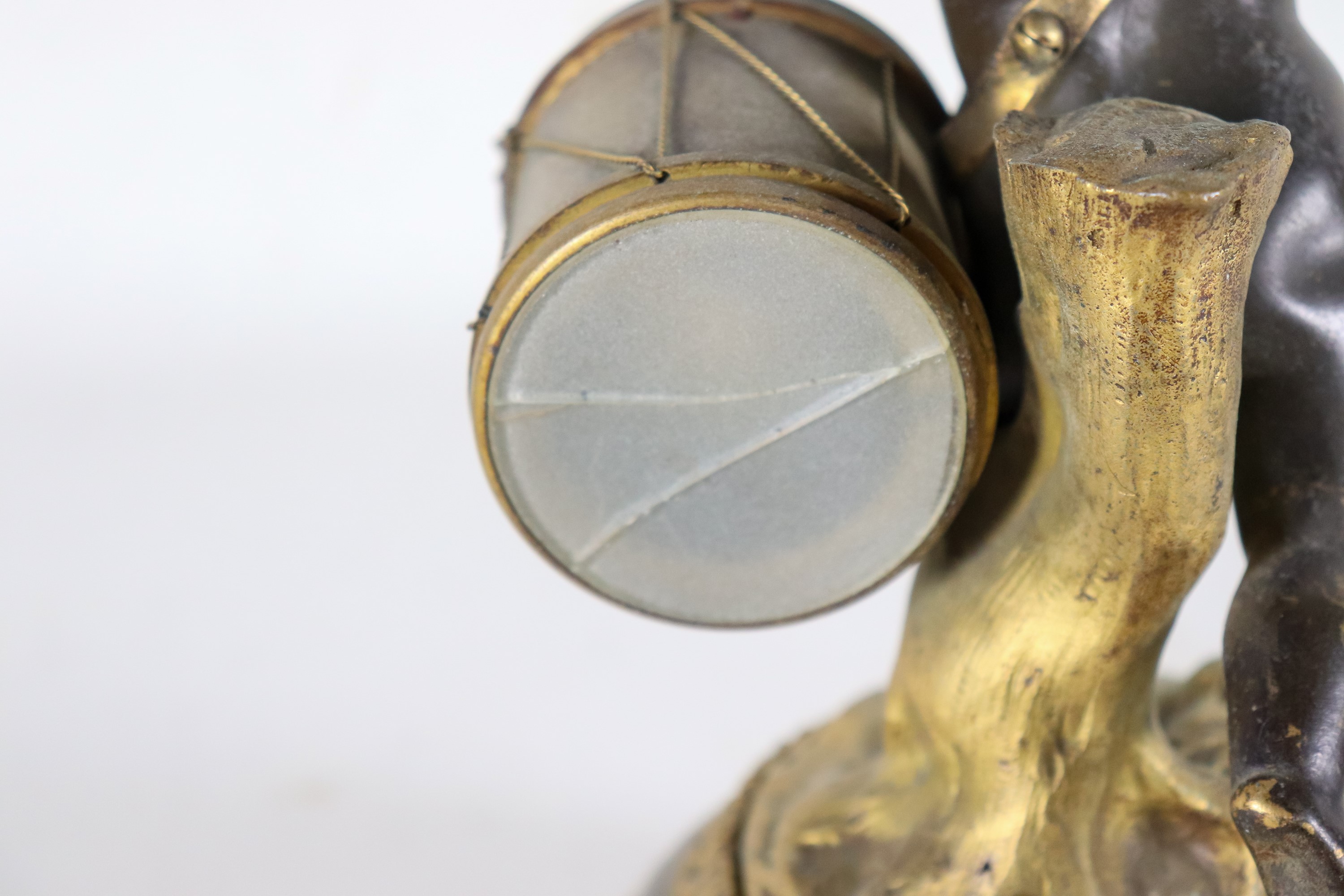 Piccolo orologio da tavolo sorretto da scultura in bronzo di "Putto suonatore", quadrante in smal...
