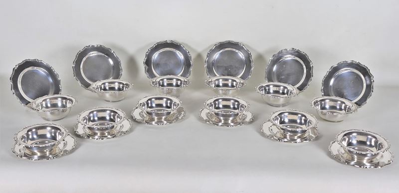 Lotto di dodici coppe con piattini in argento, con bordi centinati, cesellati e sbalzati (24 pz),...