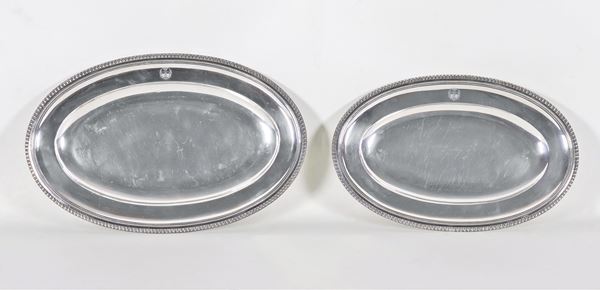 Lotto di due piatti ovali da portata in argento Titolo 950, con bordi perlinati e stemma gentilizio inciso, gr. 2110