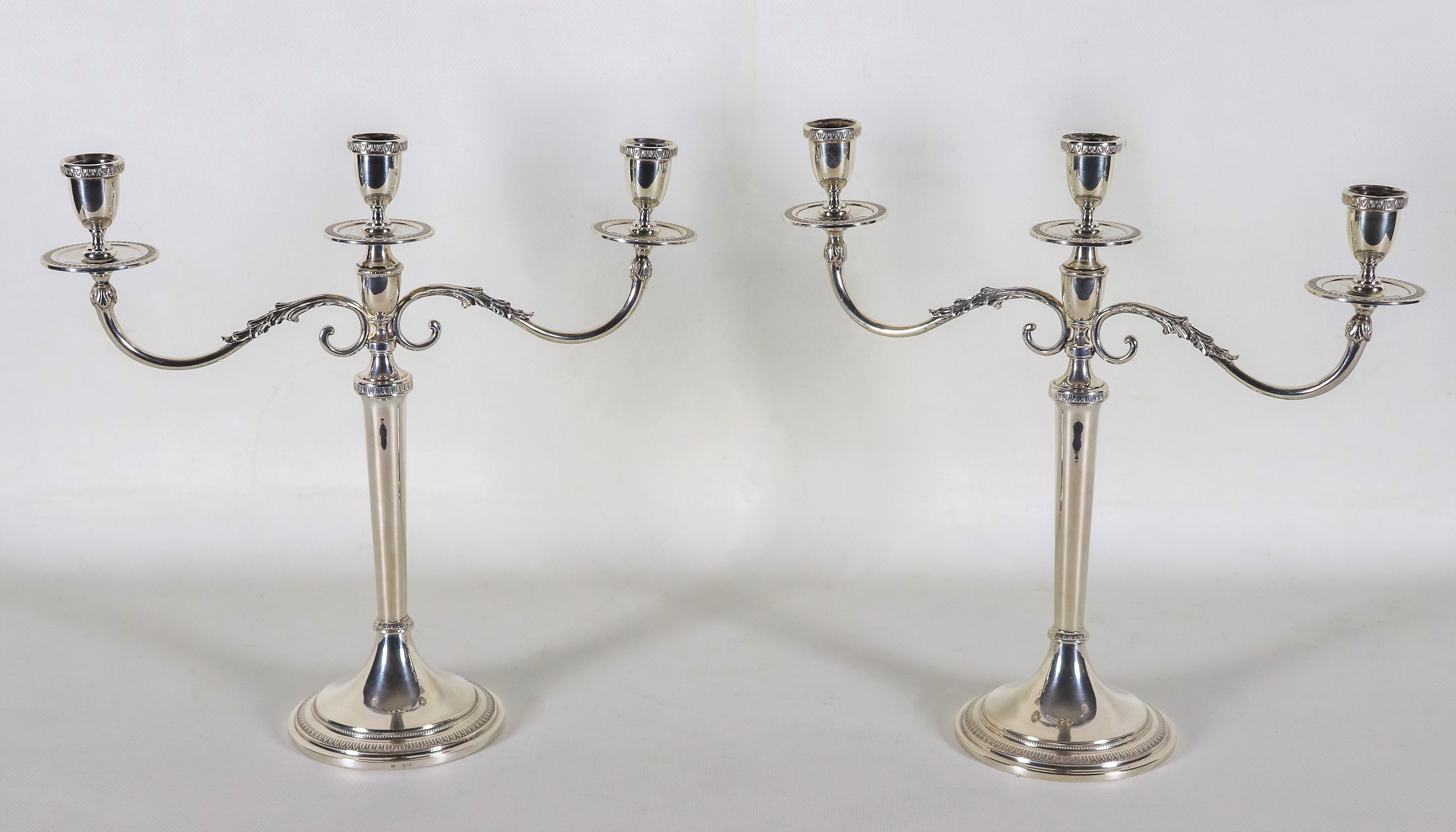 Coppia di candelabri in argento cesellato e sbalzato a motivi Impero, 3 fiamme ciascuno, gr. 1140