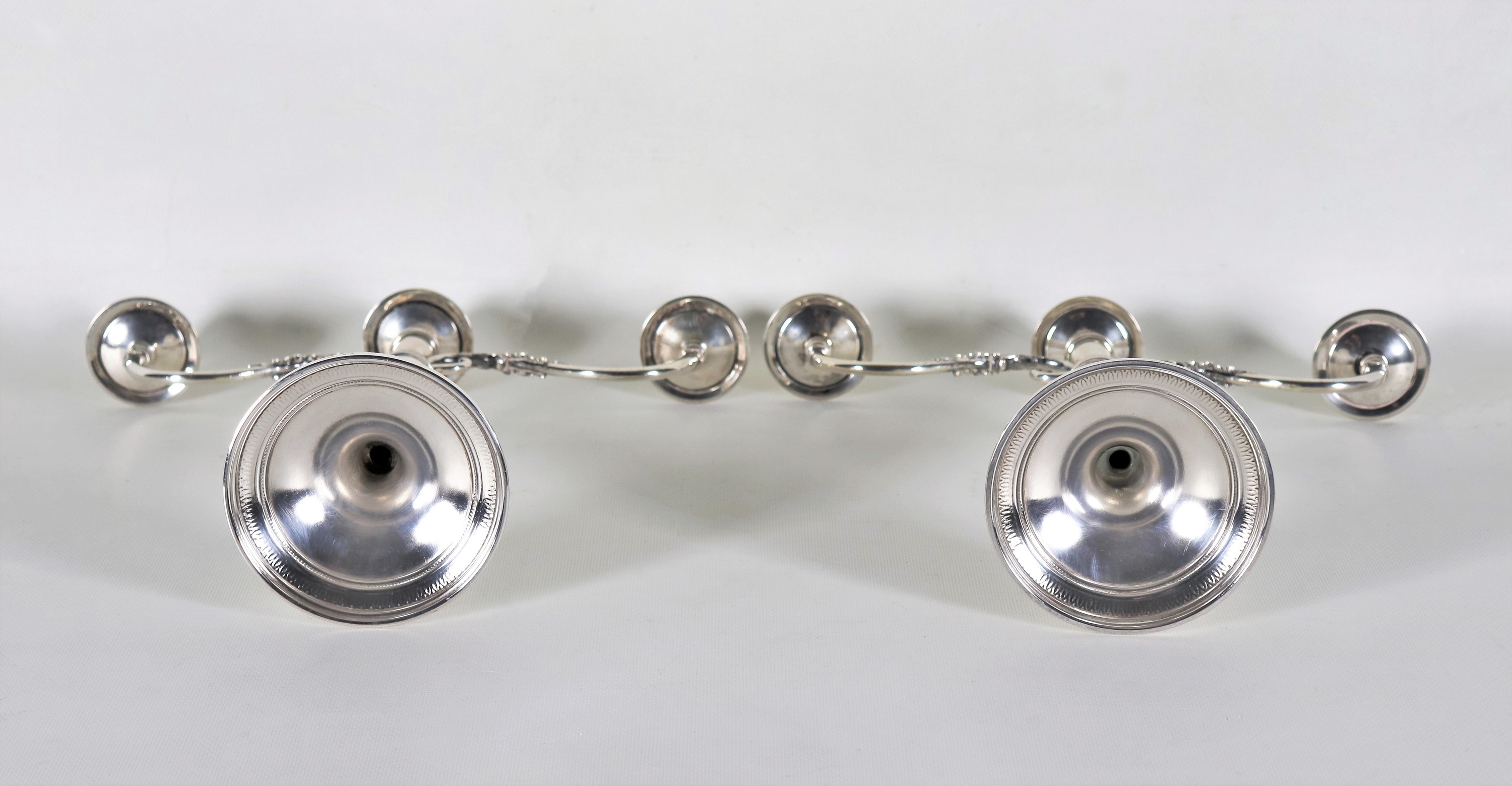 Coppia di candelabri in argento cesellato e sbalzato a motivi Impero, 3 fiamme ciascuno, gr. 1140