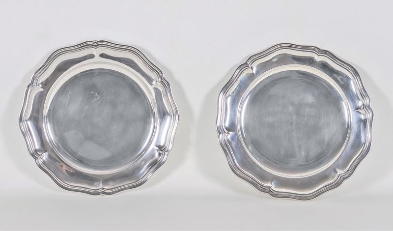 Coppia di piatti tondi in argento con bordo centinato e sbalzato, gr. 930