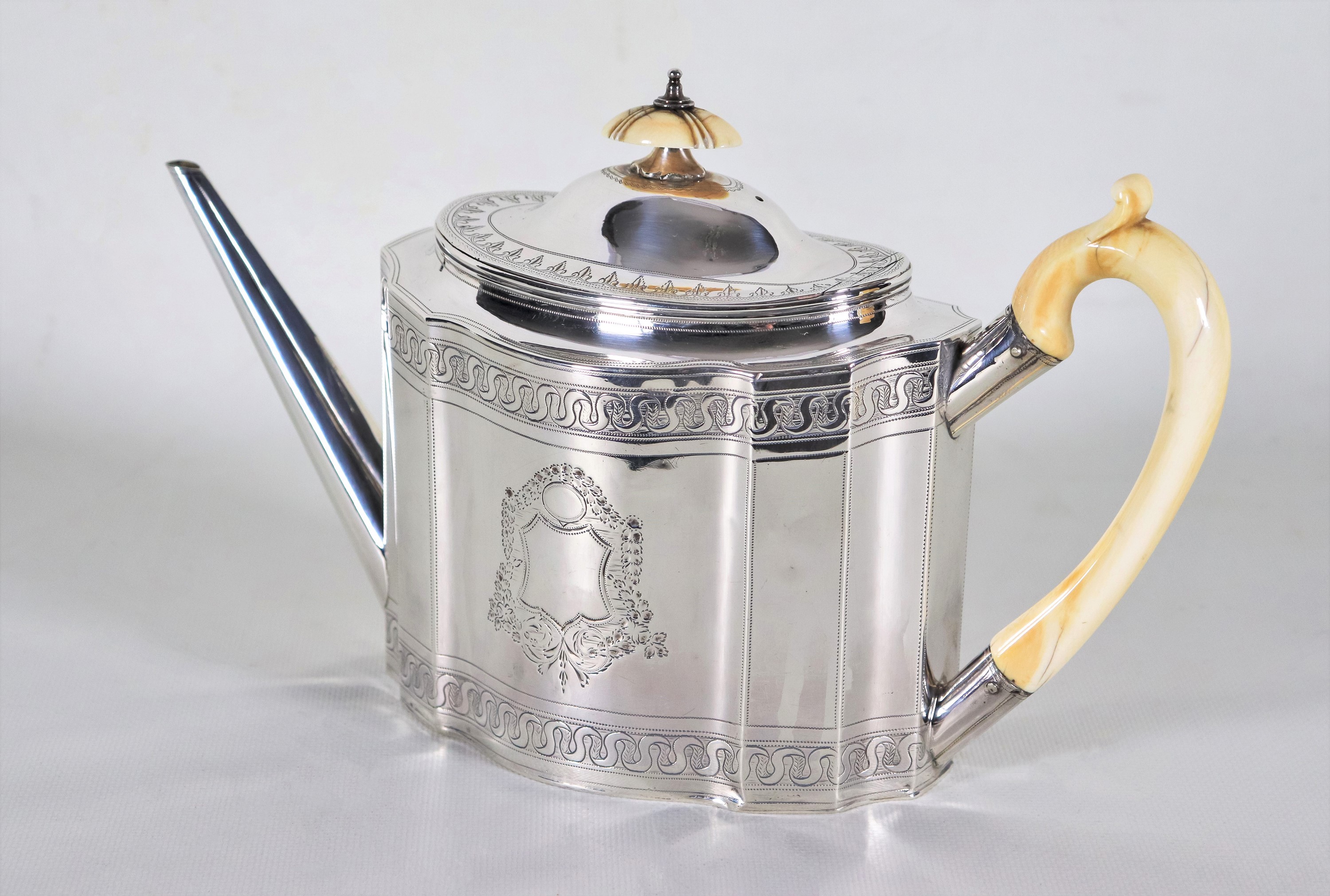 Teiera in argento Epoca Giorgio III, cesellata, sbalzata e sfaccettata, con pomo e manico in osso...