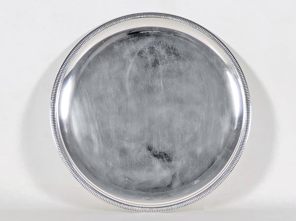 Vassoio tondo in argento con bordo a baccellature, gr. 700