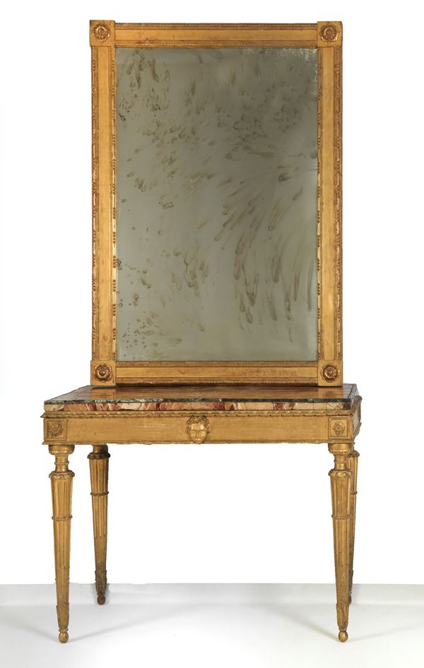 Consolle romana Luigi XVI con specchiera, in legno dorato e intagliato a motivi di mascheroni e rosoni, gambe a colonne rastremate e piano in marmo africano impiallacciato. Specchio al mercurio