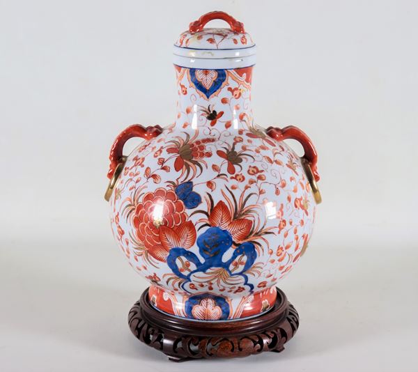 Chinese potiche in white porcelain, entirely decorated in red and blue with motifs of oriental flowers, pommel and handles in the shape of corals