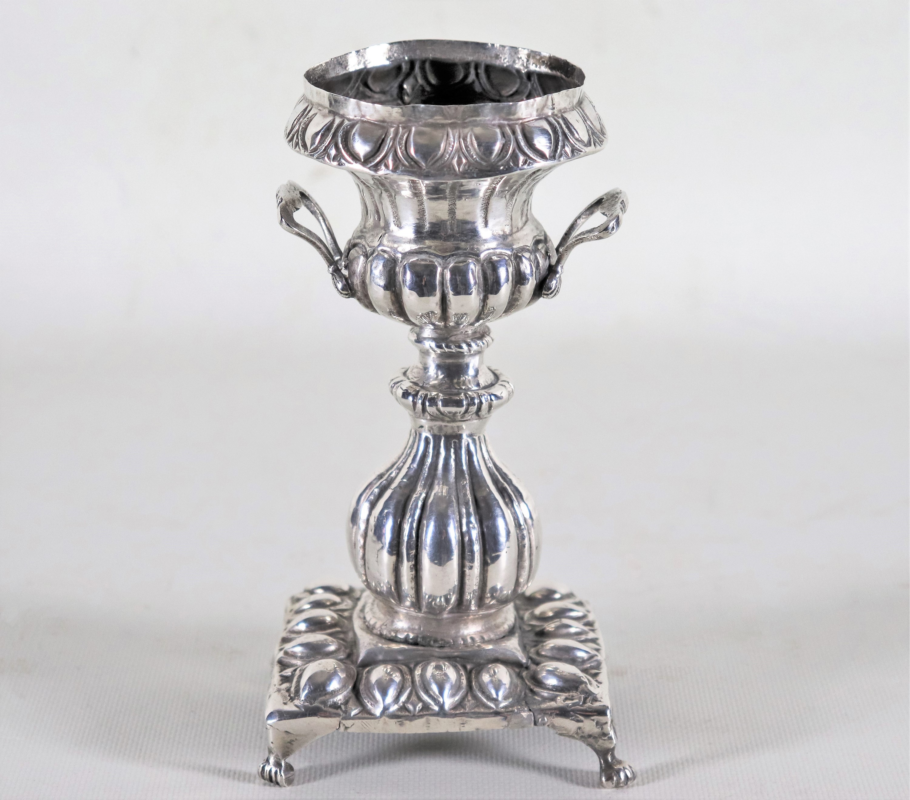 Antica piccola anfora orientale in argento cesellato e sbalzato, sorretta da quattro piedini leon...