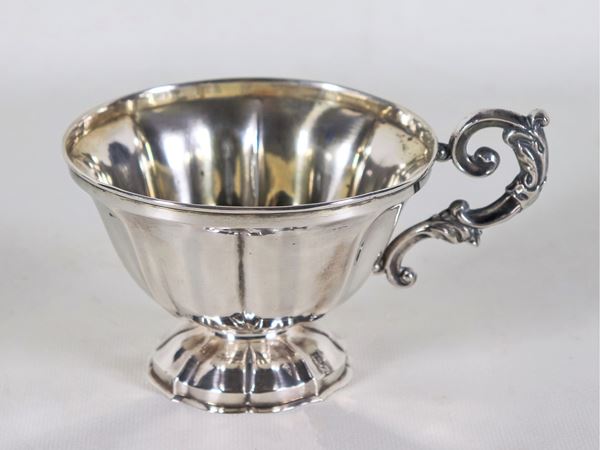 Ancient cup in chiseled and embossed silver with curved handle, gr. 110