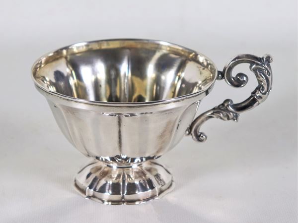 Antica tazza in argento cesellato e sbalzato con manico ricurvo, gr. 110