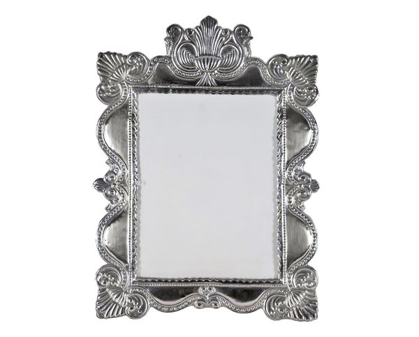 Table-top picture frame in South American silver, chiseled and embossed with volutes, palmettes and beading, arched shape