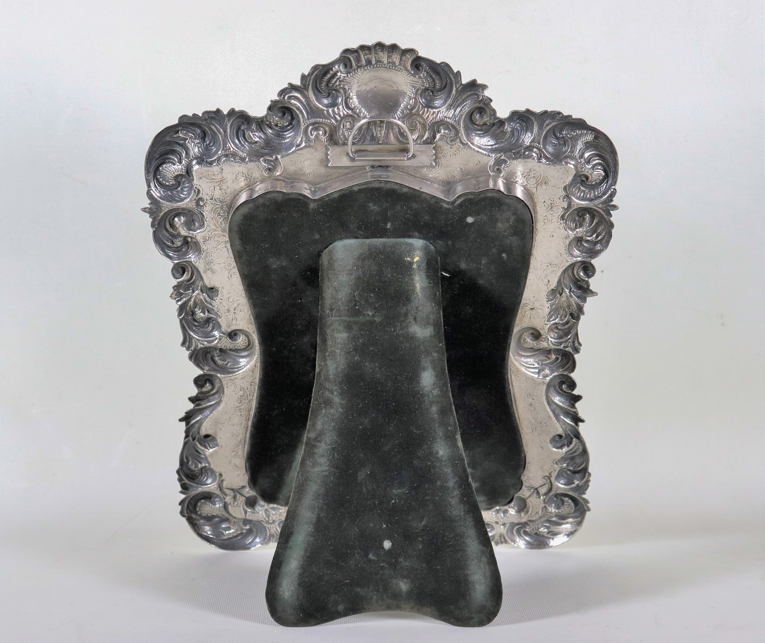 Specchiera da toletta in argento, cesellato e sbalzato a motivi Luigi XV di volute d'acanto e con...