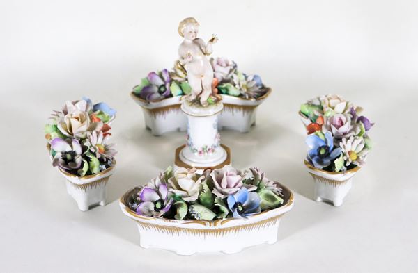 Piccolo centrotavola in porcellana policroma Capodimonte, composto da quattro vasche con mazzi di fiori e statuina di putto al centro                          (5 pz)