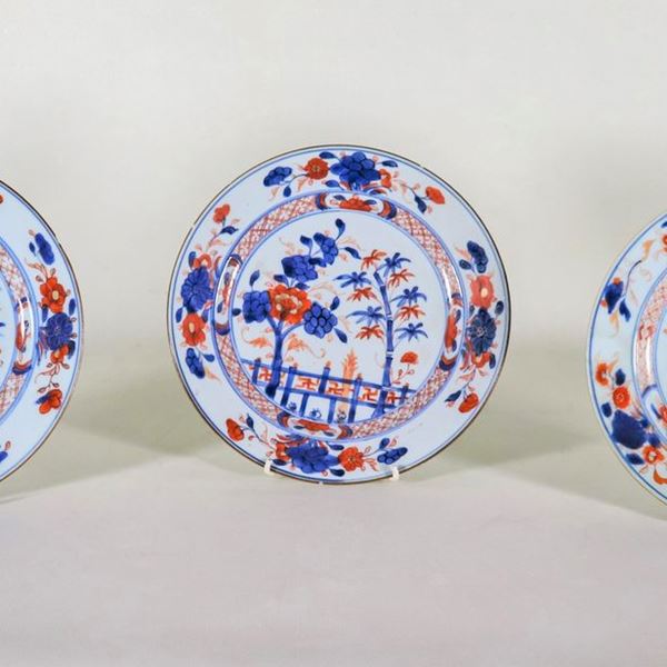 Lotto di tre antichi piatti cinesi in porcellana Imari, con decorazioni variopinte a motivi di fiori e alberi orientali