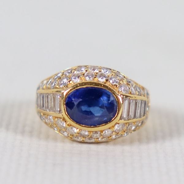 Anello in oro giallo 18kt con zaffiro centrale e piccoli diamanti a baguette su pavè di diamantini, gr. 8 circa, misura 5