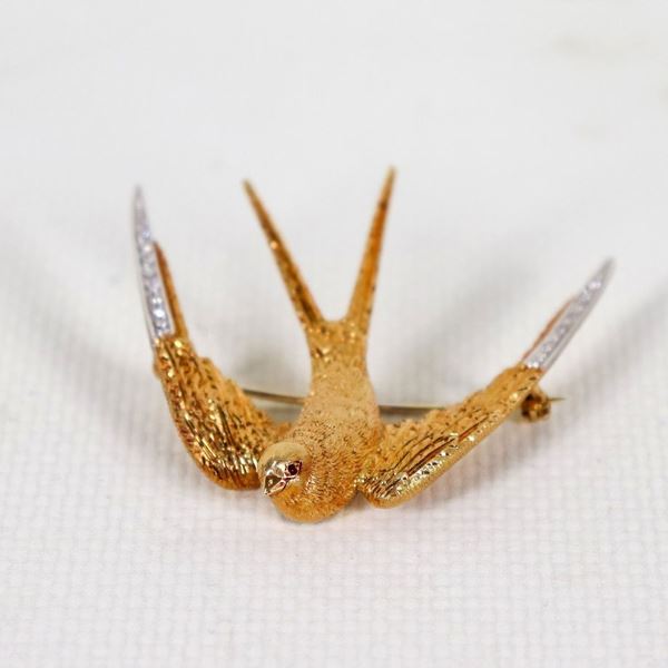 Spilla "Rondine" in oro giallo 18kt, con pavè di piccoli diamanti sulle ali, gr. 12 circa, cm 5 x 5