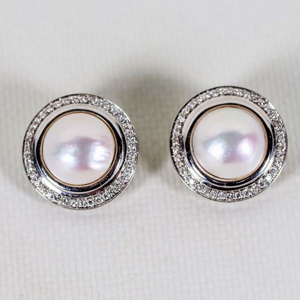 Pair of 18kt white gold clip earrings with large central pearl surrounded by a series of small diamonds, gr. about 17
