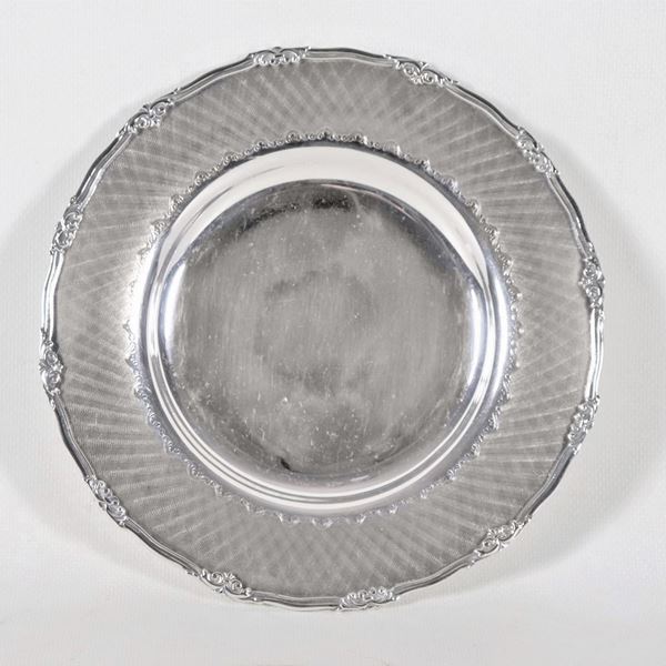 Piattino tondo in argento con bordo cesellato e sbalzato, gr. 280