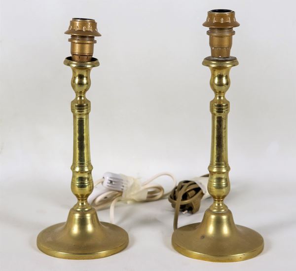 Coppia di candelieri francesi di linea Luigi XVI in metallo dorato e sbalzato