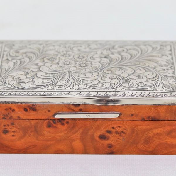 Cigarette case in thuja briar, with lid covered in chiseled and embossed silver, small dent on the edge