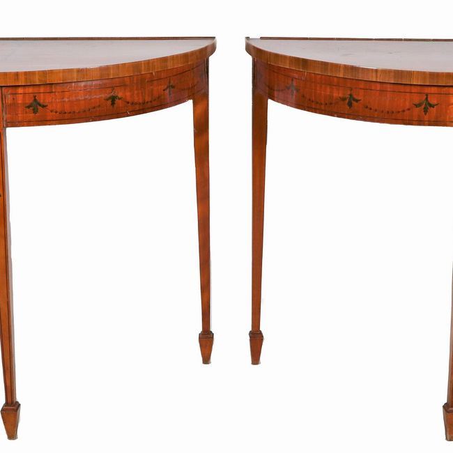 Coppia di consolles inglesi a demi-lune in satinwood, con decori dipinti a motivi Sheraton, tre g...