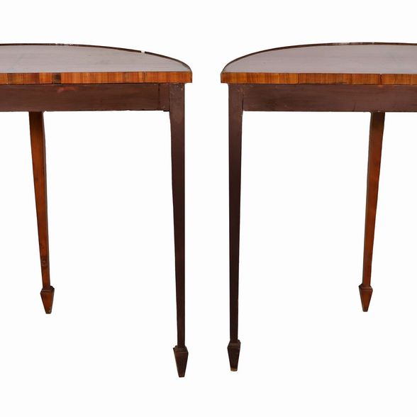 Coppia di consolles inglesi a demi-lune in satinwood, con decori dipinti a motivi Sheraton, tre g...