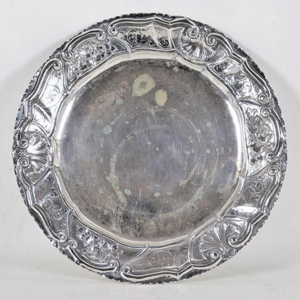 Antique round plate in silver, with chiseled and embossed border with floral scrolls and shells, gr. 520