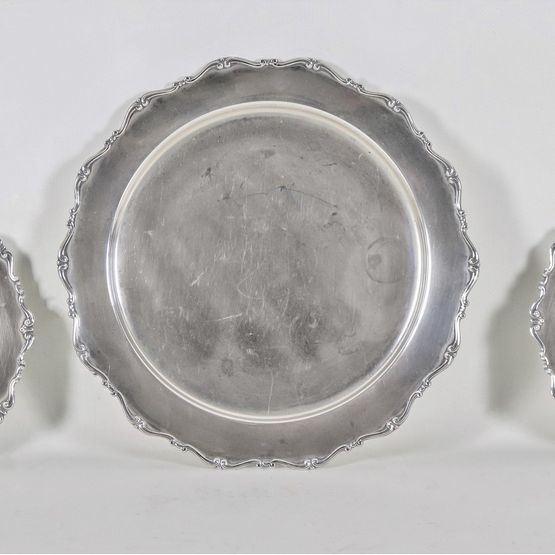 Lot of three round silver plates with chiseled and embossed edges with scrolls and palmettes, one large and two small, gr. 1040