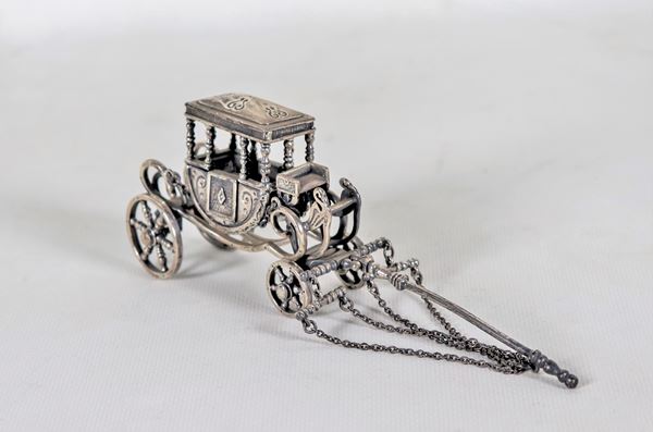 Model of an ancient carriage in chiselled and embossed silver, missing a small chain, gr. 200