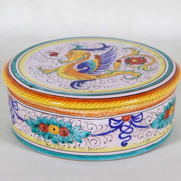 Scatola tonda in maiolica smaltata Deruta con decorazioni policrome a motivi di grifo e ghirlande di frutta